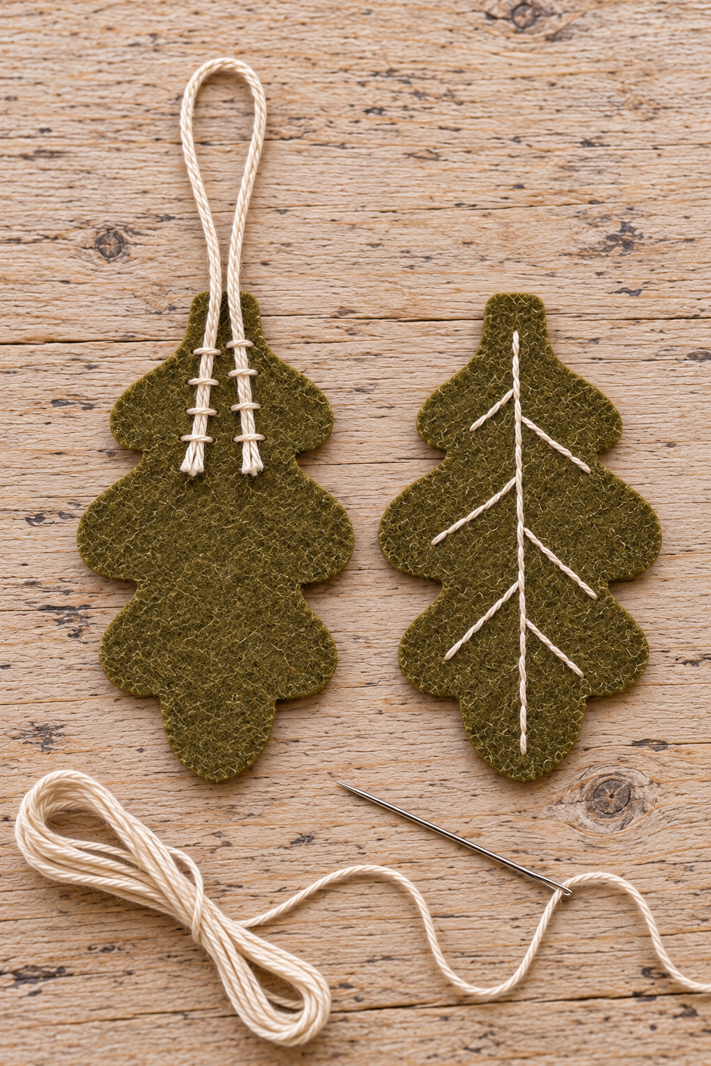 Cream cord ends stitched onto a felt leaf back beside the embroidered front.