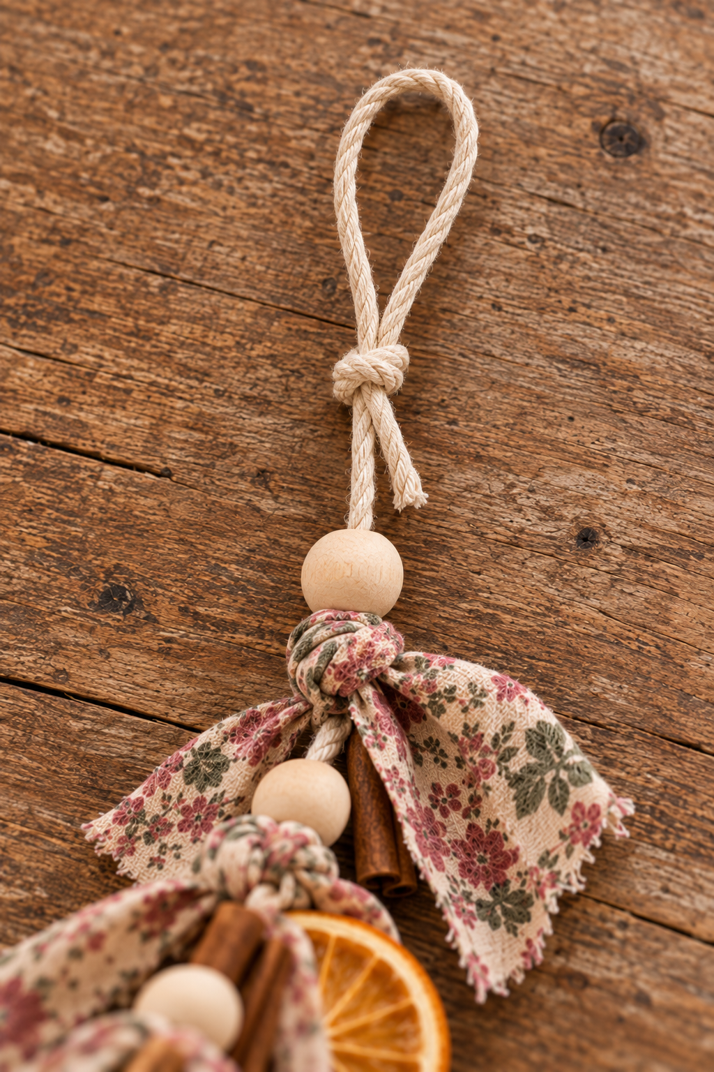 Cotton cord end secured in a hanging loop above a wood bead and floral fabric strip.