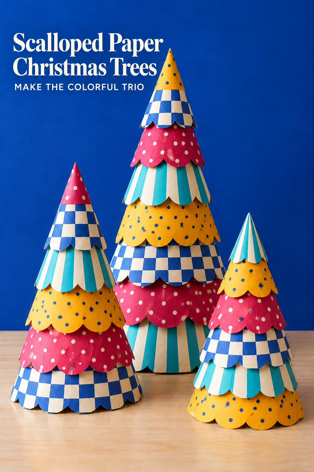 Three paper Christmas trees with colorful scalloped layers against a blue backdrop.