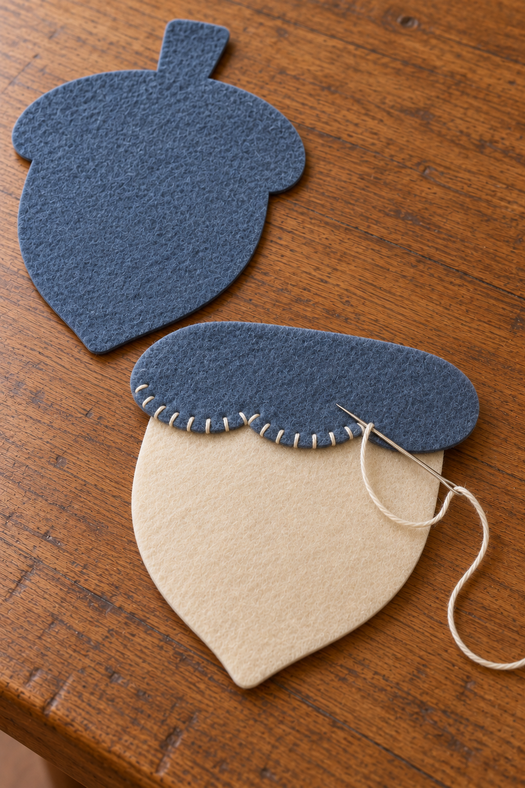 Ivory blanket stitches joining a blue scalloped cap to the ivory felt front body.