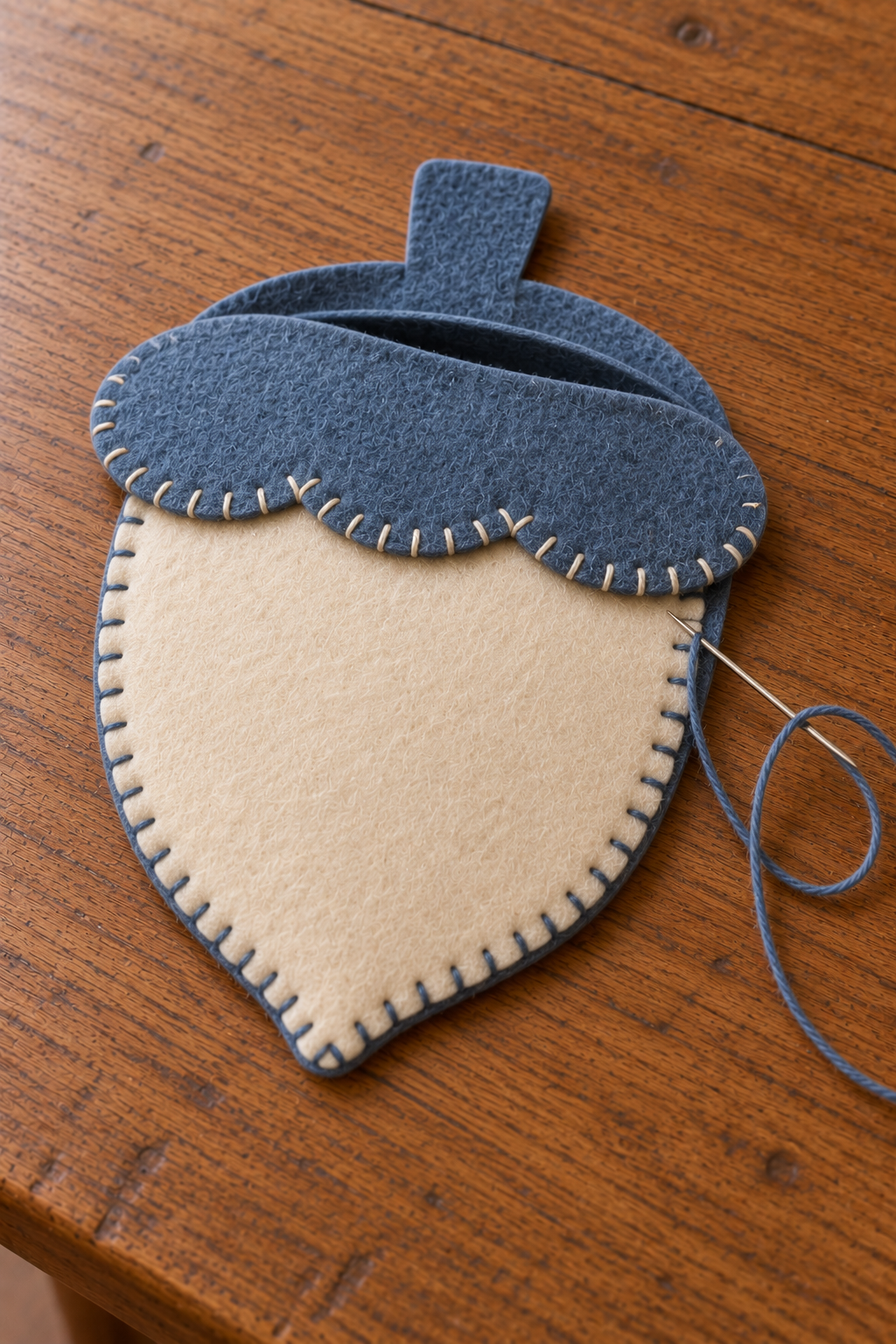 Blue stitching joins the acorn pocket layers while the upper opening remains unsewn.