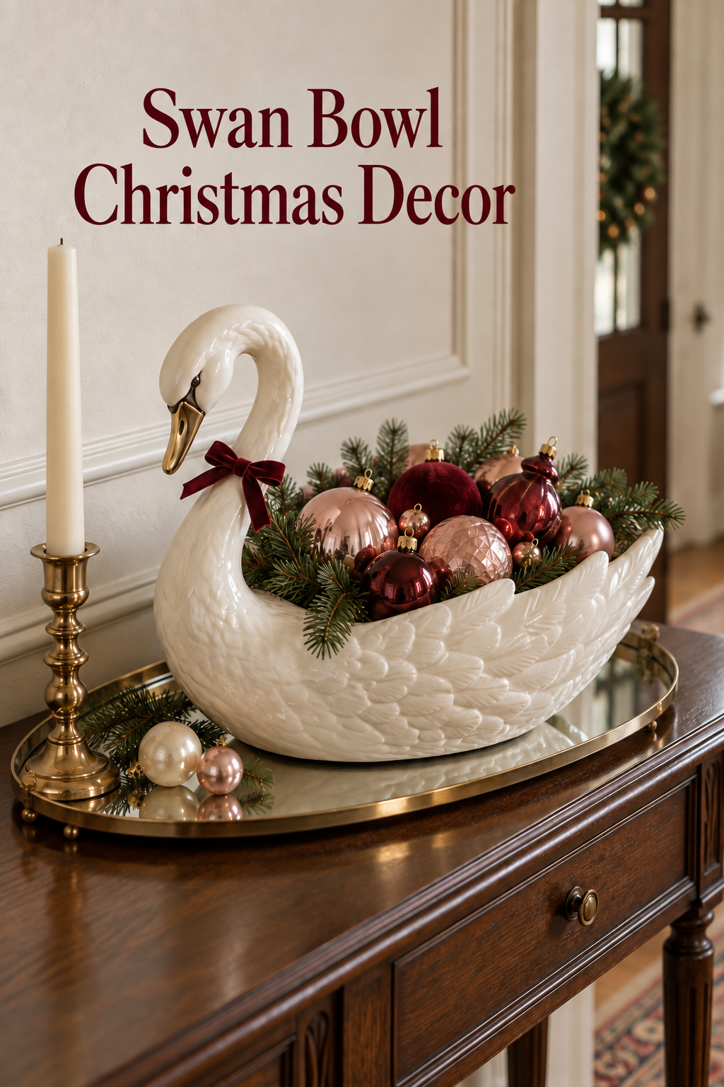 White swan bowl with pink and burgundy Christmas ornaments on a mirrored console tray.